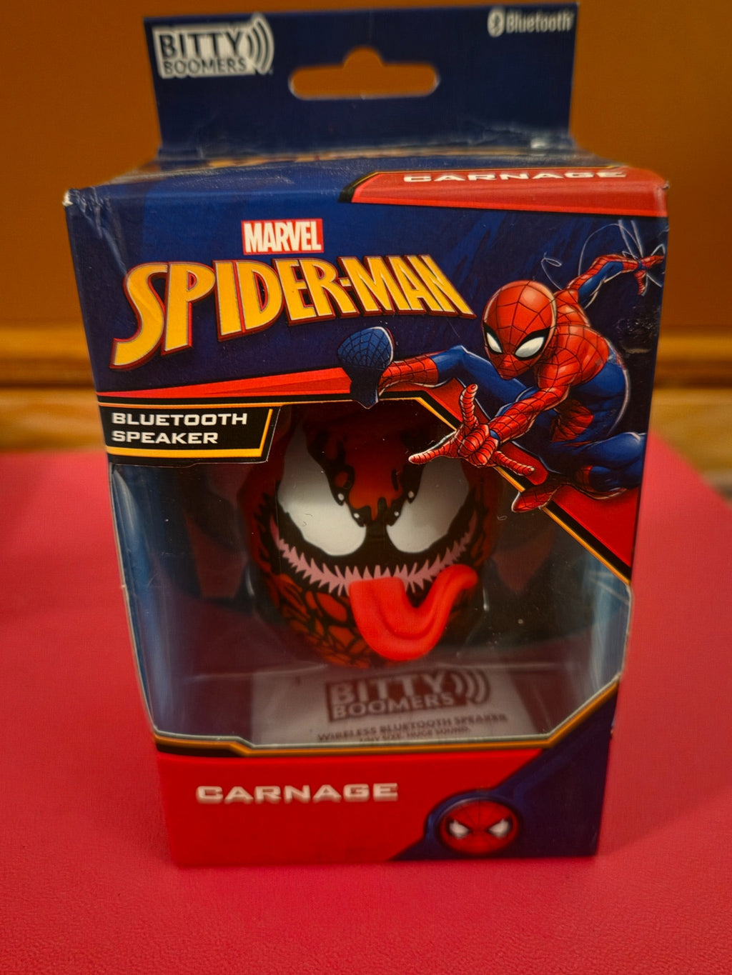 Front view of Marvel Spider-Man Carnage Bitty Boomers Bluetooth speaker in retail box